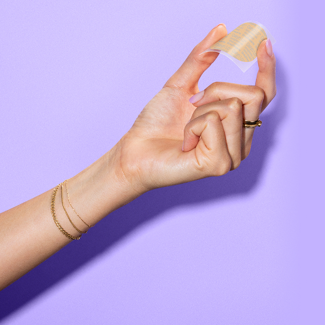 A hand holding the Gwyn Lo birth control patch